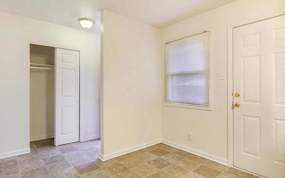 an empty room with a white door and a window