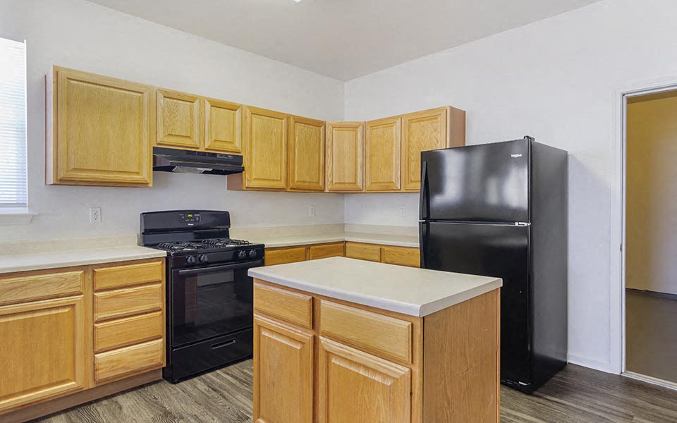 a kitchen with black appliances and wooden cabinets
