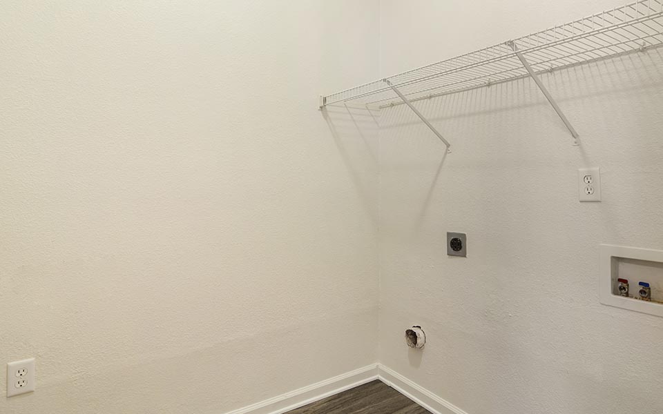 a white bathroom with a wire rack on the wall