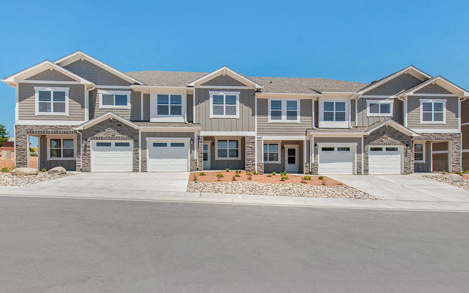a large house with garage doors and a street in front of it