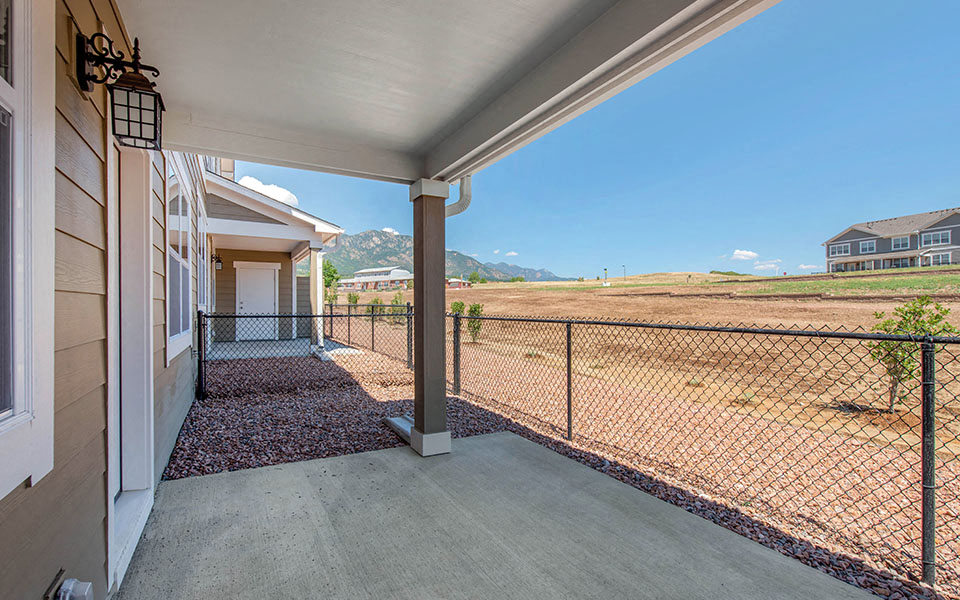 the view from the front porch of a house with a chain link fence