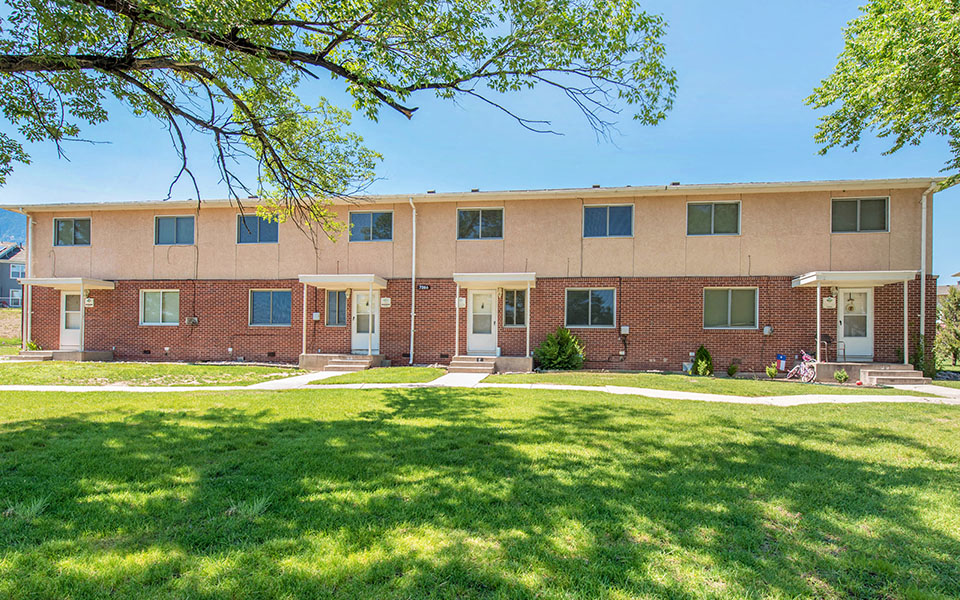 a large brick building with a lawn in front of it