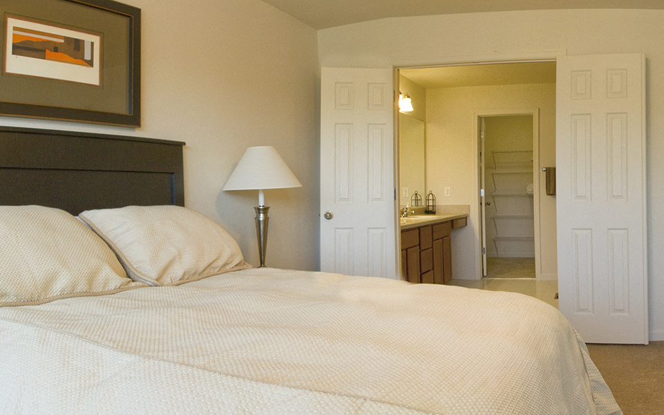 a bedroom with a bed and a bathroom with a sink