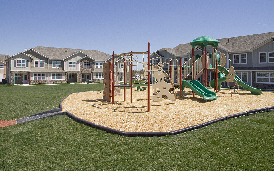 a playground with apartments in the background