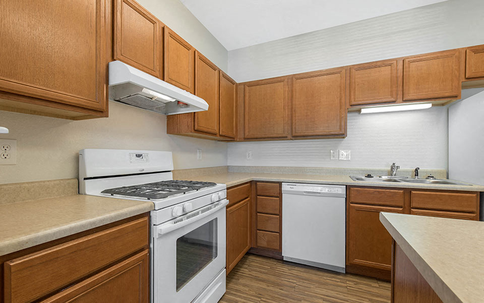 a kitchen with white appliances and wooden cabinets