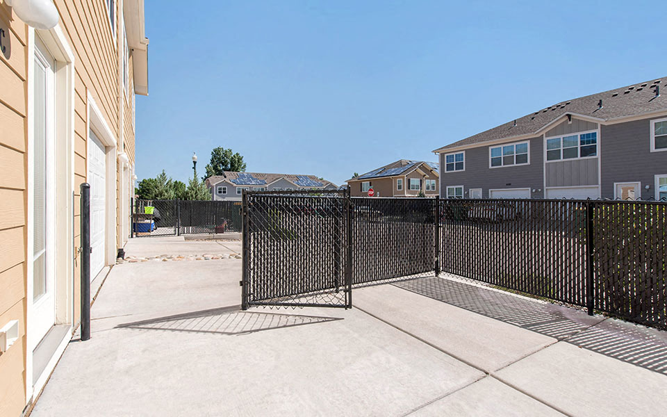 the yard is fenced off with a wrought iron fence