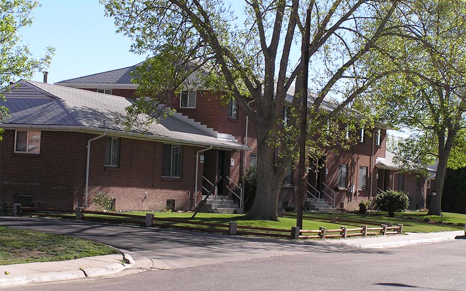 a red brick house on the side of a street