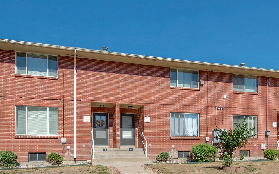 the front of a brick building with a blue sky