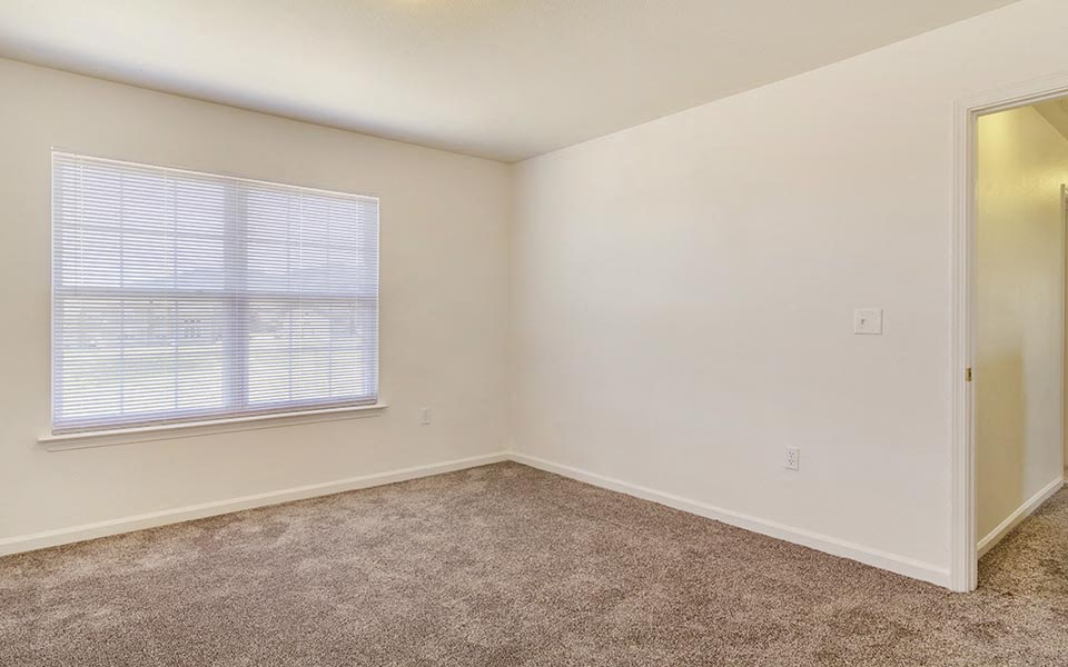 an empty room with a window and a door