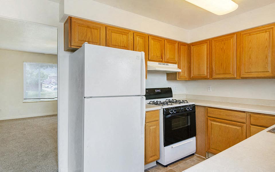 a kitchen with white appliances and wooden cabinets
