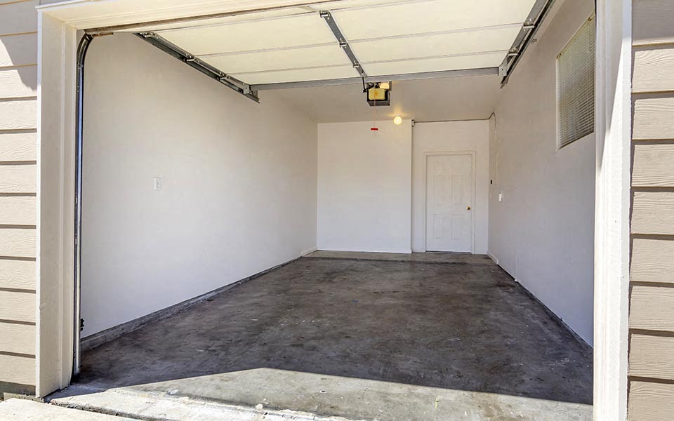an empty garage with white walls and a white door