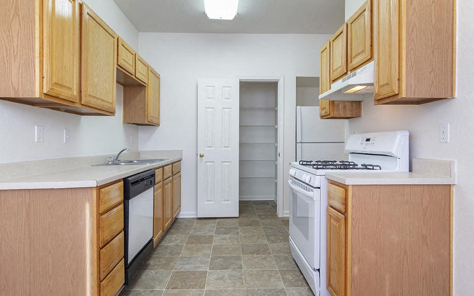 a kitchen with wooden cabinets and white appliances