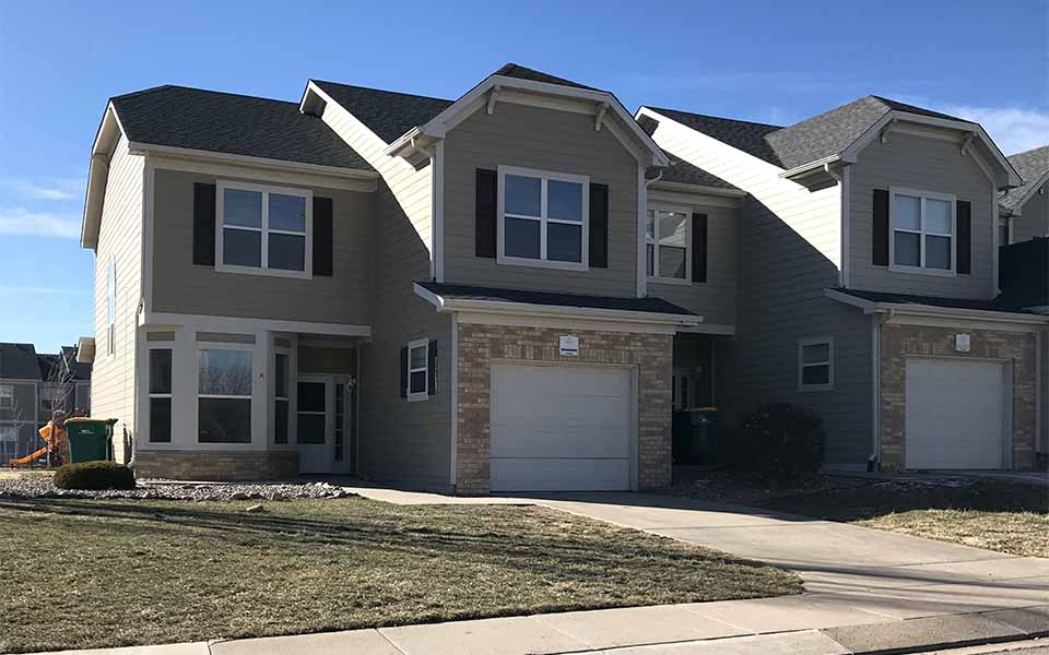 a house with two garage doors and a sidewalk