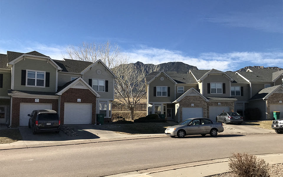 a street of houses with mountains in the background