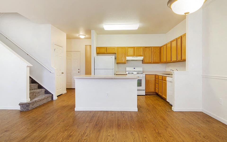 an empty kitchen with a white counter top