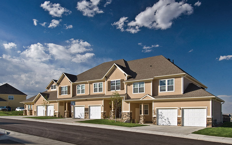 a row of houses with garage doors on a street