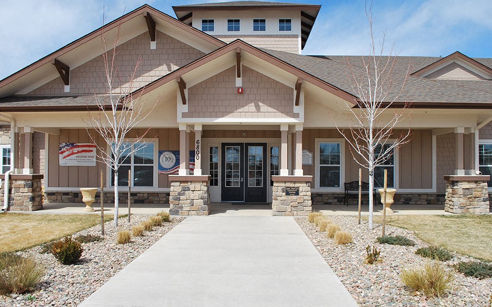 the front entrance of a building with a walkway and trees