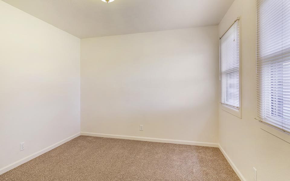 an empty room with white walls and a window