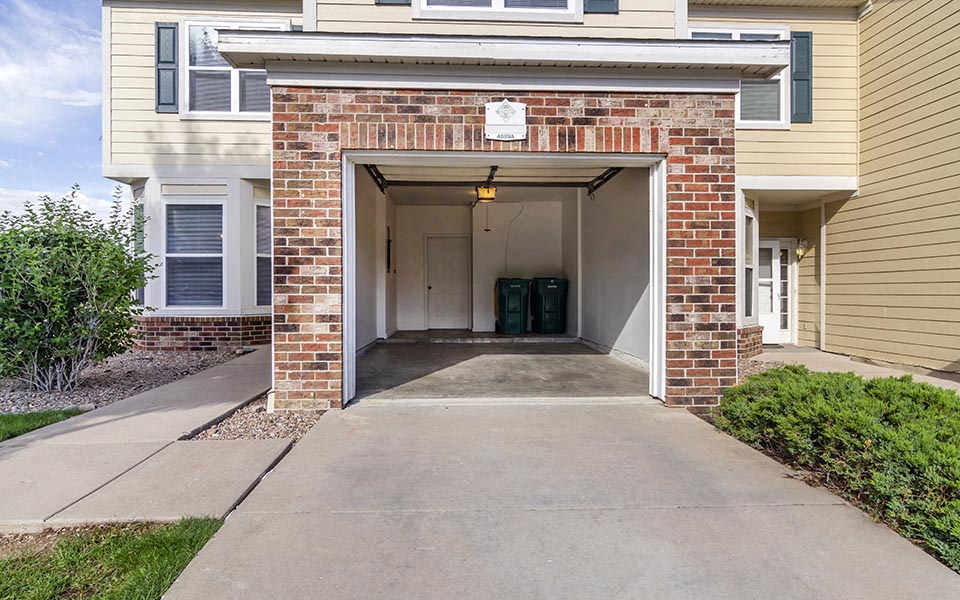 a walkway in front of a building with a garage door