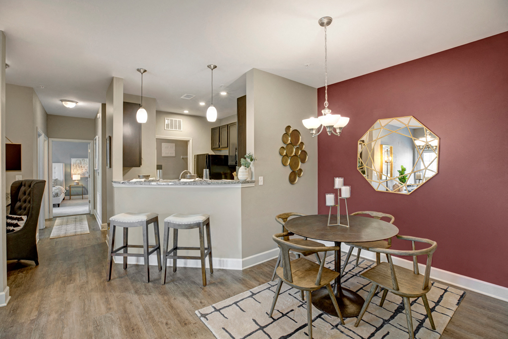 Dining room and kitchen. Stools at kitchen. Small dining room table with four chairs at Ascent at Mallard Creek Charlotte, NC
