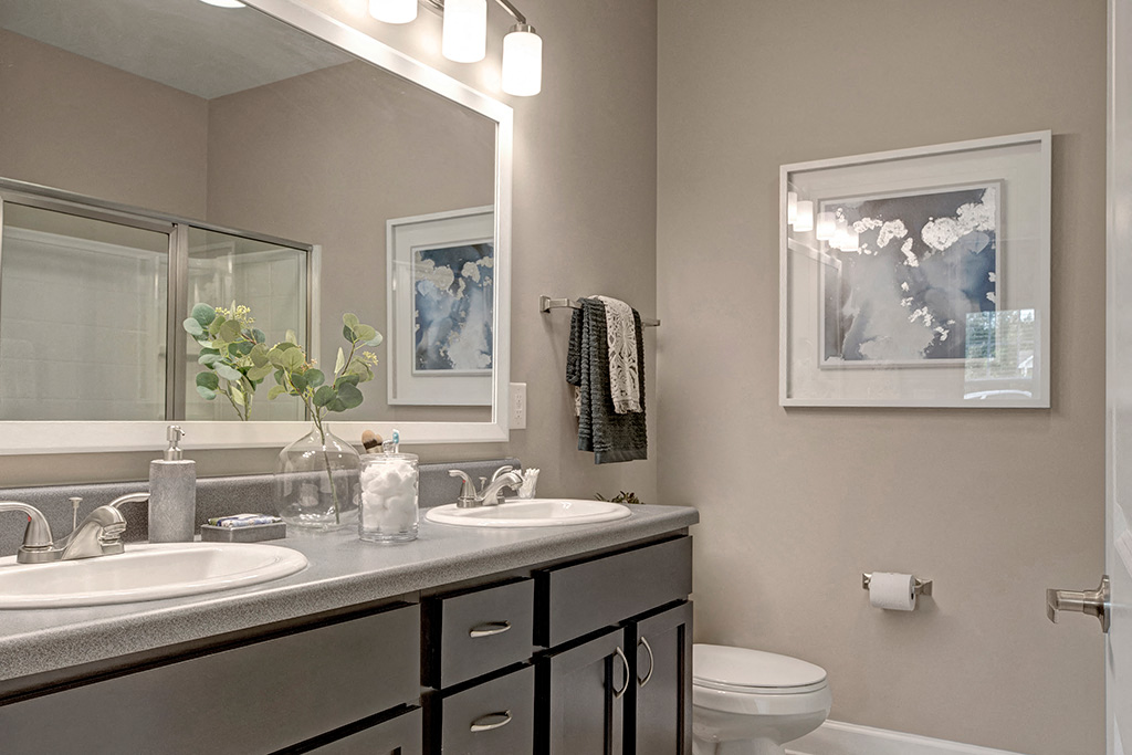 Bathroom with two sinks, dark cabinets at Ascent at Mallard Creek Charlotte, NC