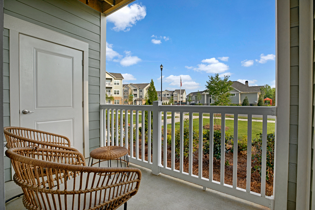 Balcony with two patio chairs and a table. Storage space on balcony at Ascent at Mallard Creek Charlotte, NC