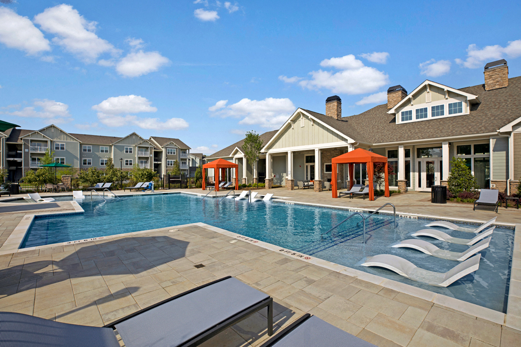 Swimming Pool. Big spacious pool with chairs in shallow end, loungers, cabanas at Ascent at Mallard Creek Charlotte, NC