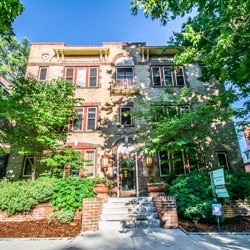 a large brick house with trees in front of it