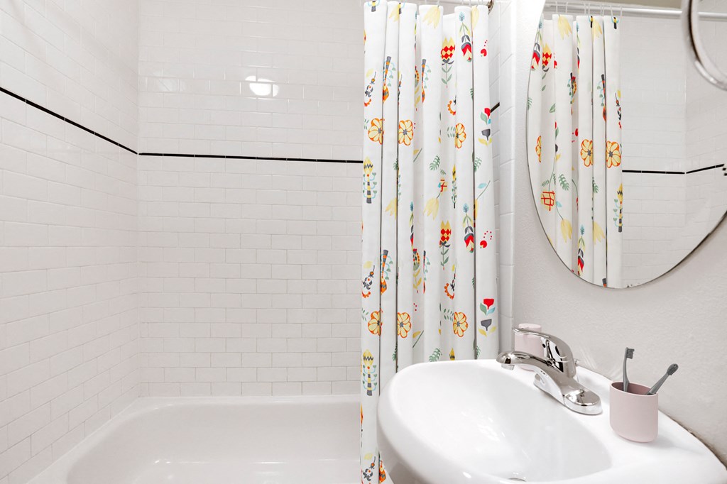 a white bathroom with a sink and a shower curtain