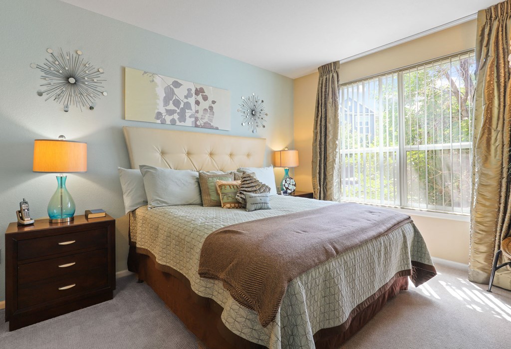 a bedroom with a bed and a large window