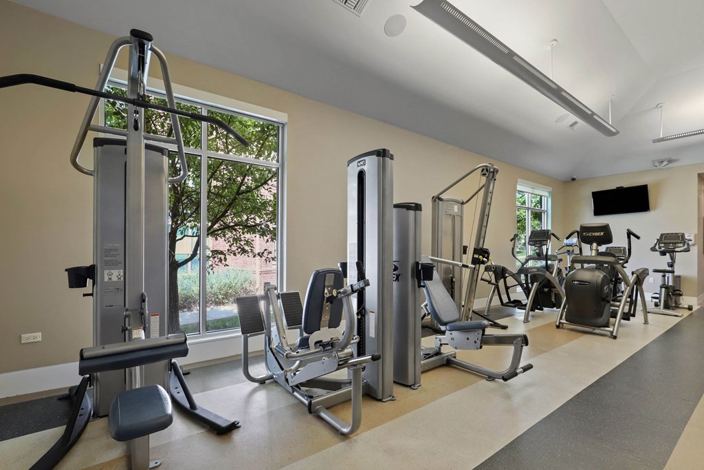 a gym with exercise equipment and a large window