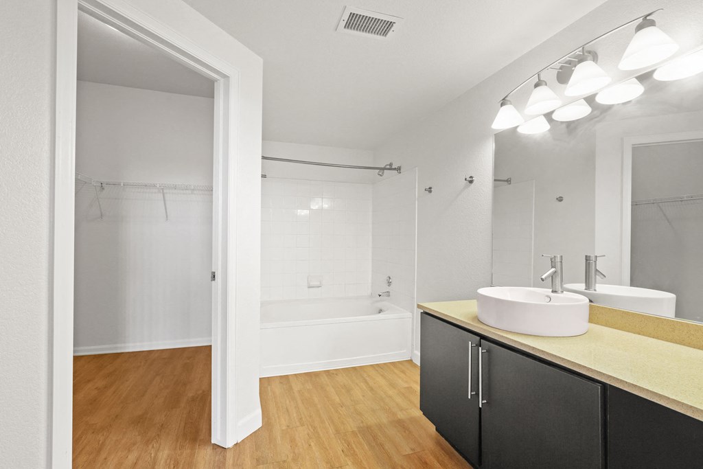 a bathroom with a sink and a shower and a mirror
