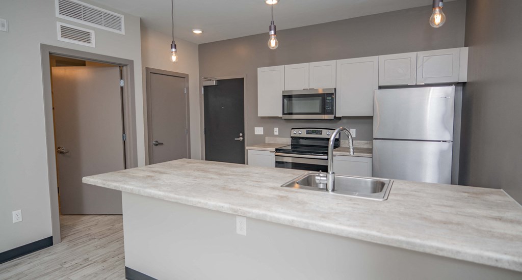 a kitchen with stainless steel appliances and a marble counter top
