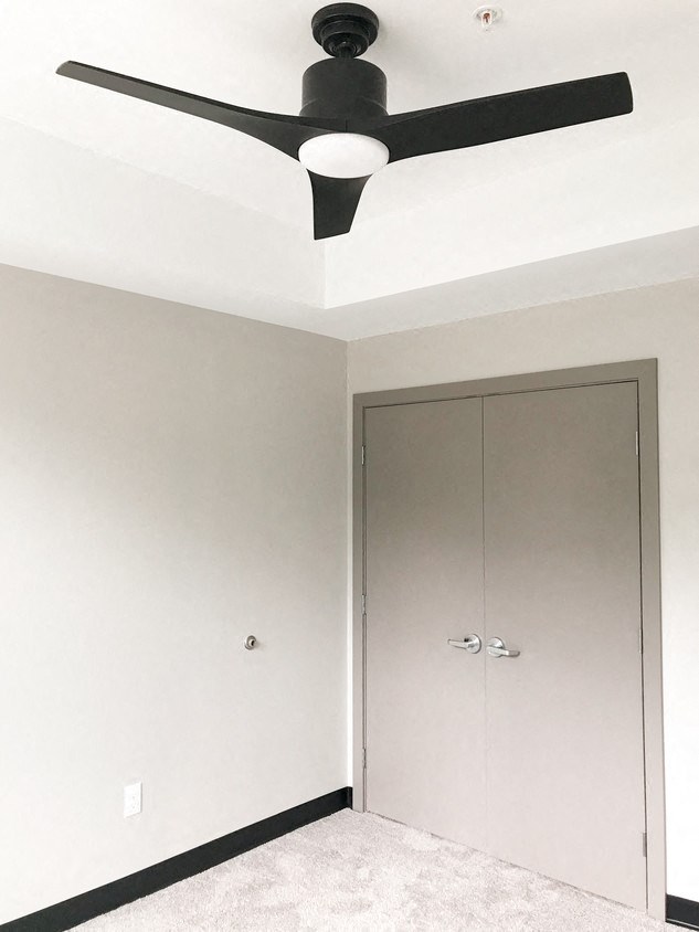 an empty room with a ceiling fan and a closet
