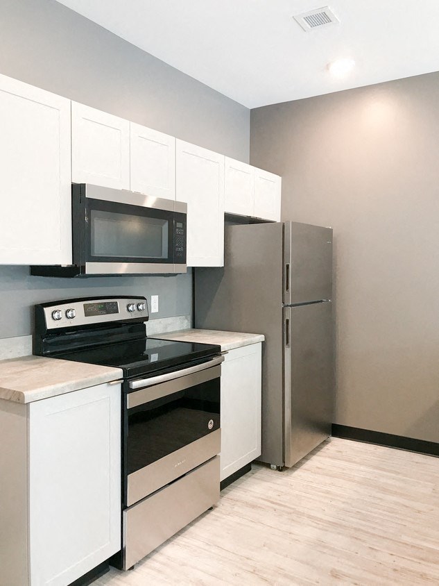 a kitchen with stainless steel appliances and white cabinets