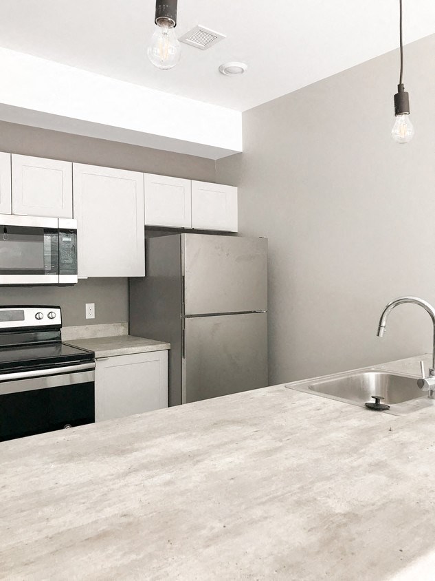 a kitchen with stainless steel appliances and a marble counter top