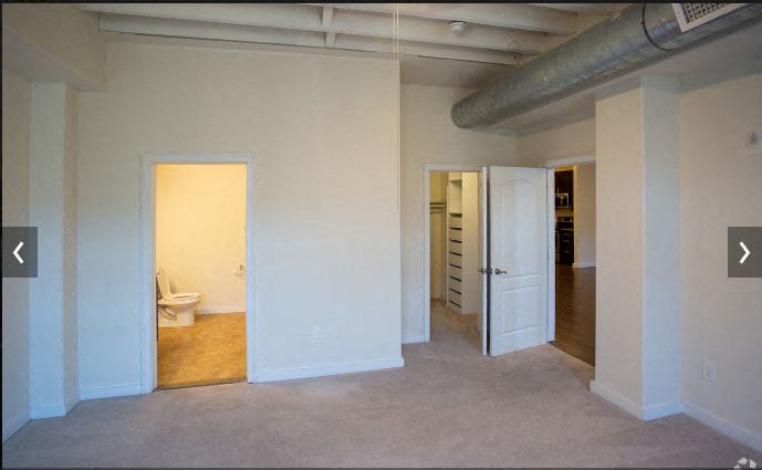 an empty room with a toilet and a door