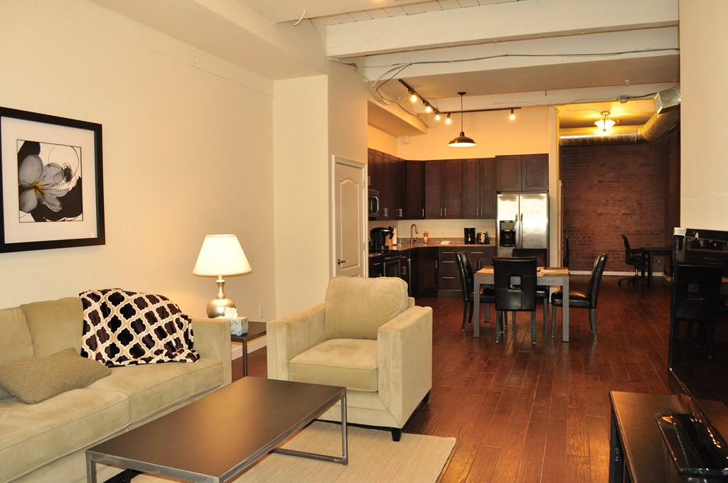 a living room and kitchen with a couch and a table