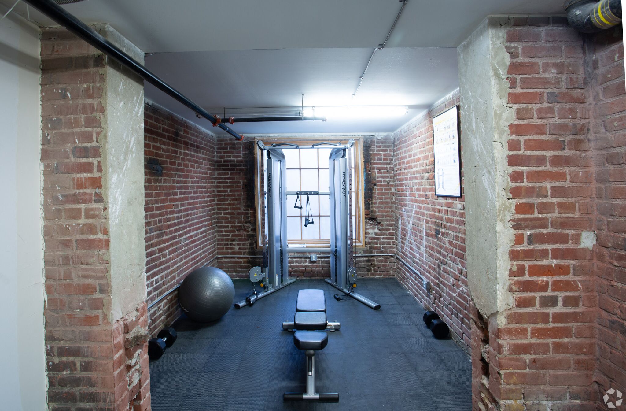 a fitness room with brick walls and weights