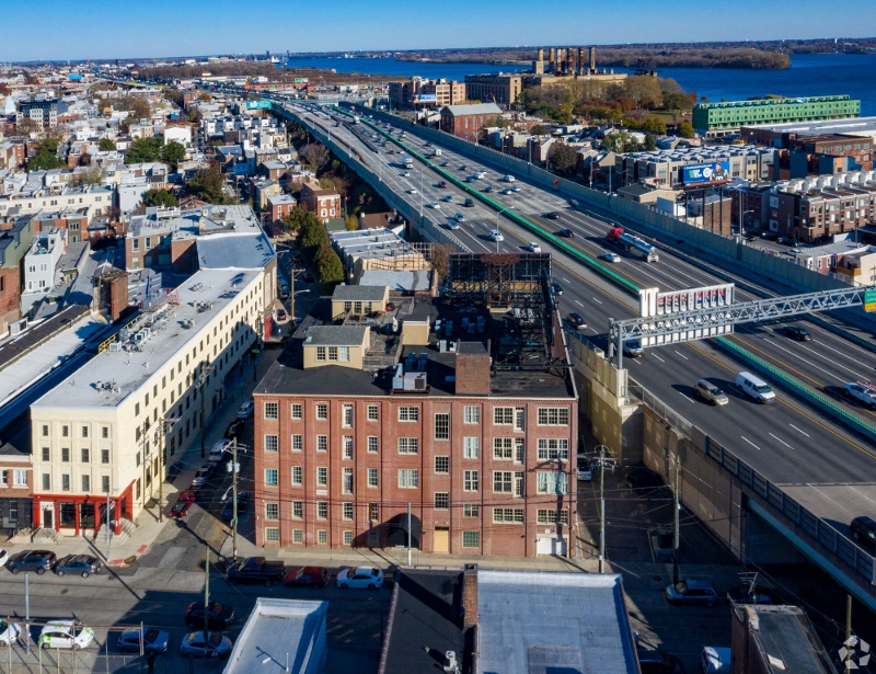 an aerial view of a city with a bridge and train tracks