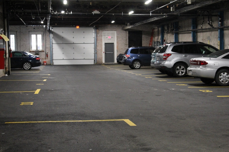A parking garage with several cars parked in it.