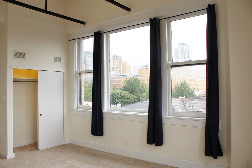 a living room with three windows and a door