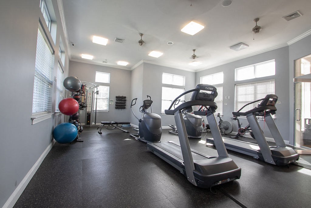 a gym with cardio equipment and weights in a building