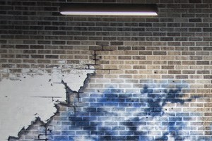 interior a gym with weights and a strong sign on a brick wall