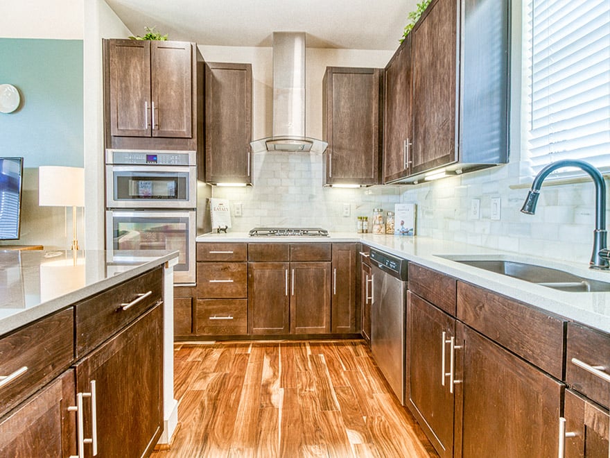 A kitchen with wooden cabinets and a stainless steel oven.