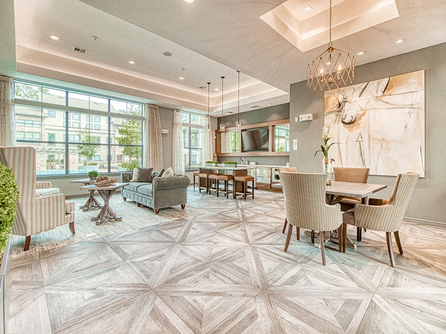 A living room with a large rug and a dining table with chairs.