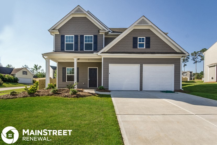 a home with a garage door and a driveway