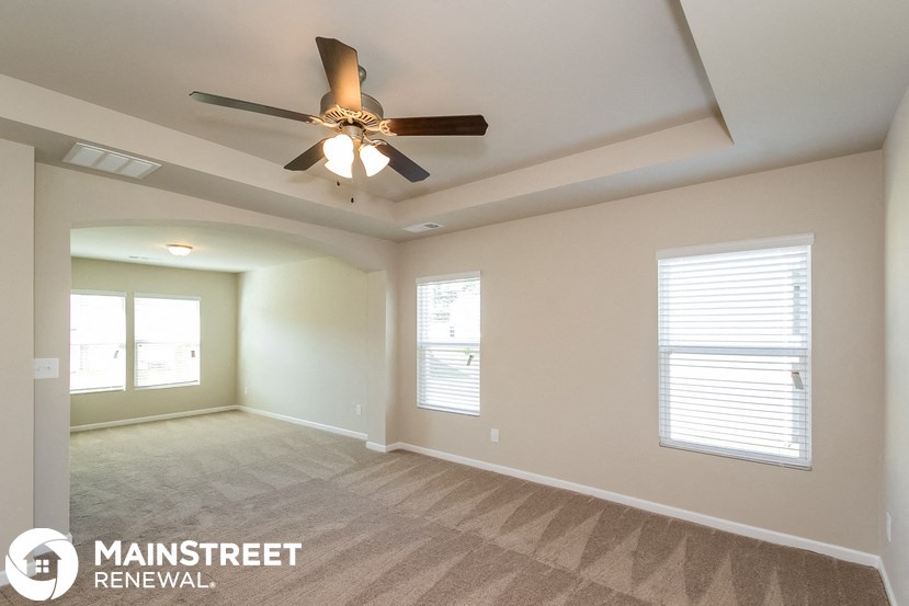 a living room with a ceiling fan and a window