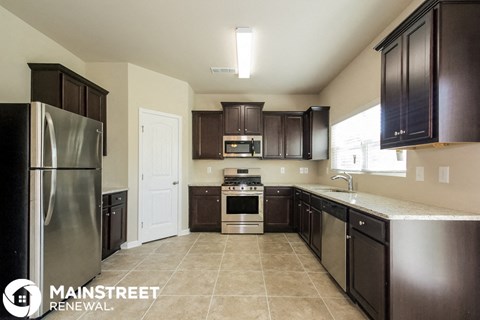 a kitchen with dark wood cabinets and stainless steel appliances