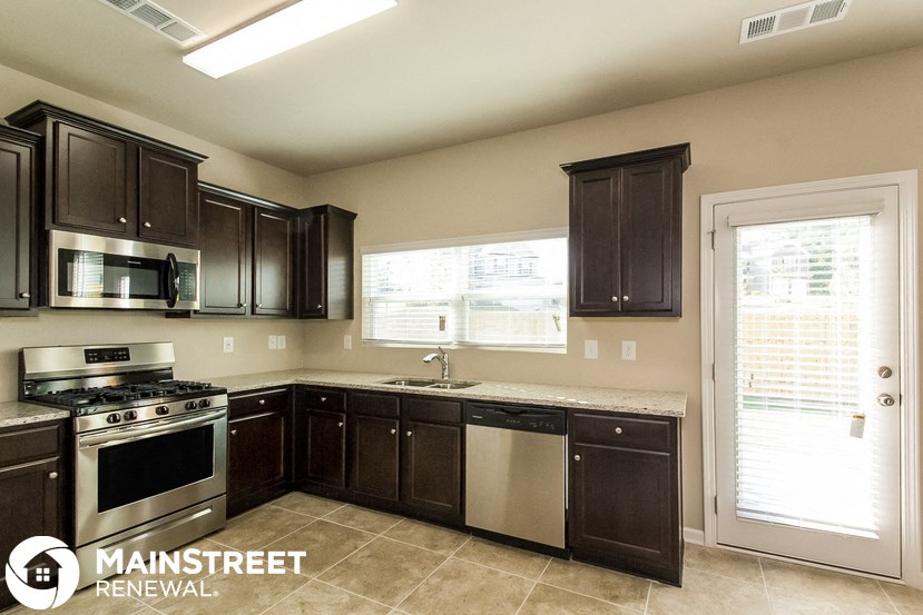 a kitchen with dark wood cabinets and stainless steel appliances